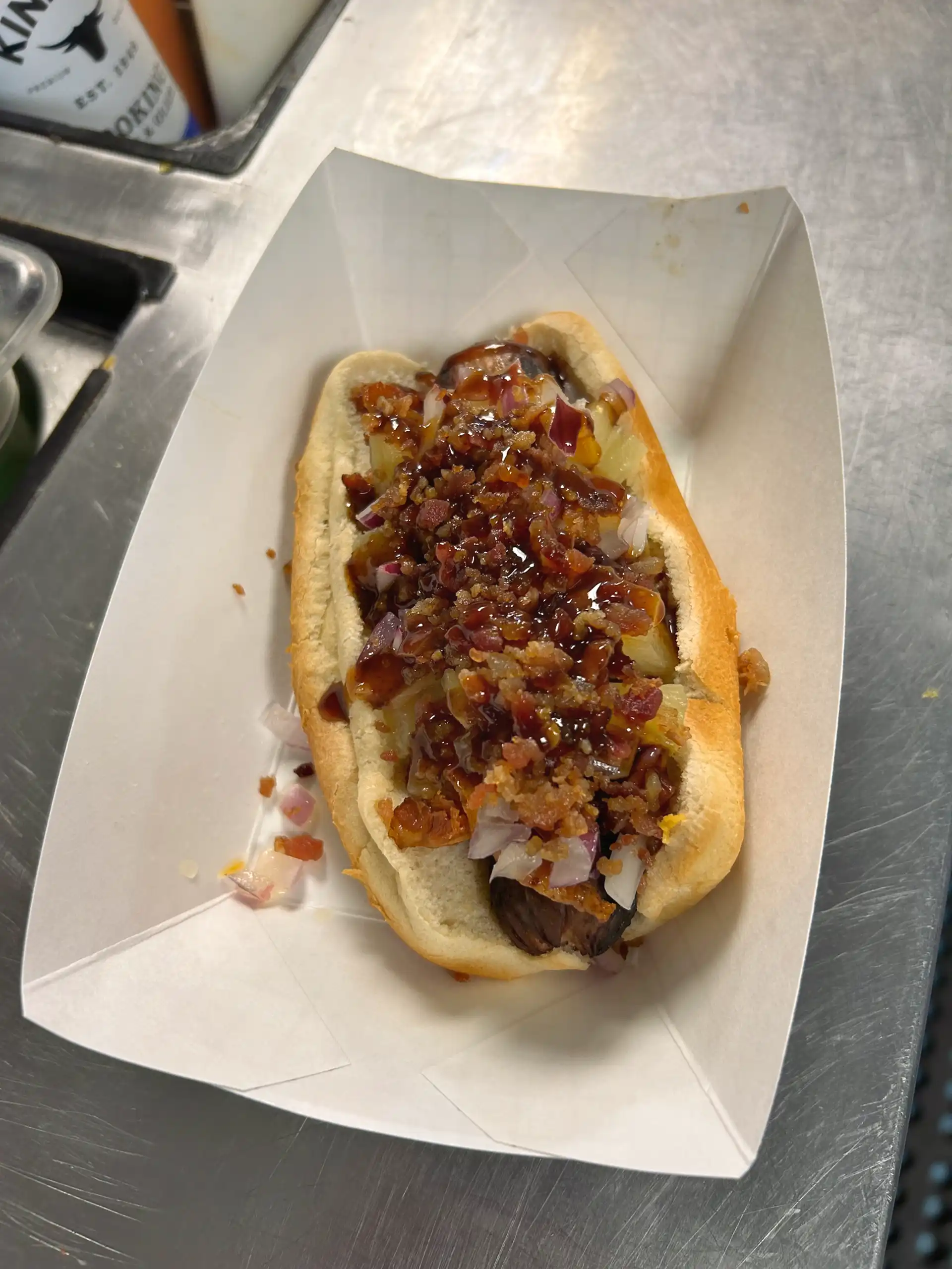 Smoked all beef 1/4 lb. wien with a bacon strip, pineapple, red onion, and Japanese BBQ sauce