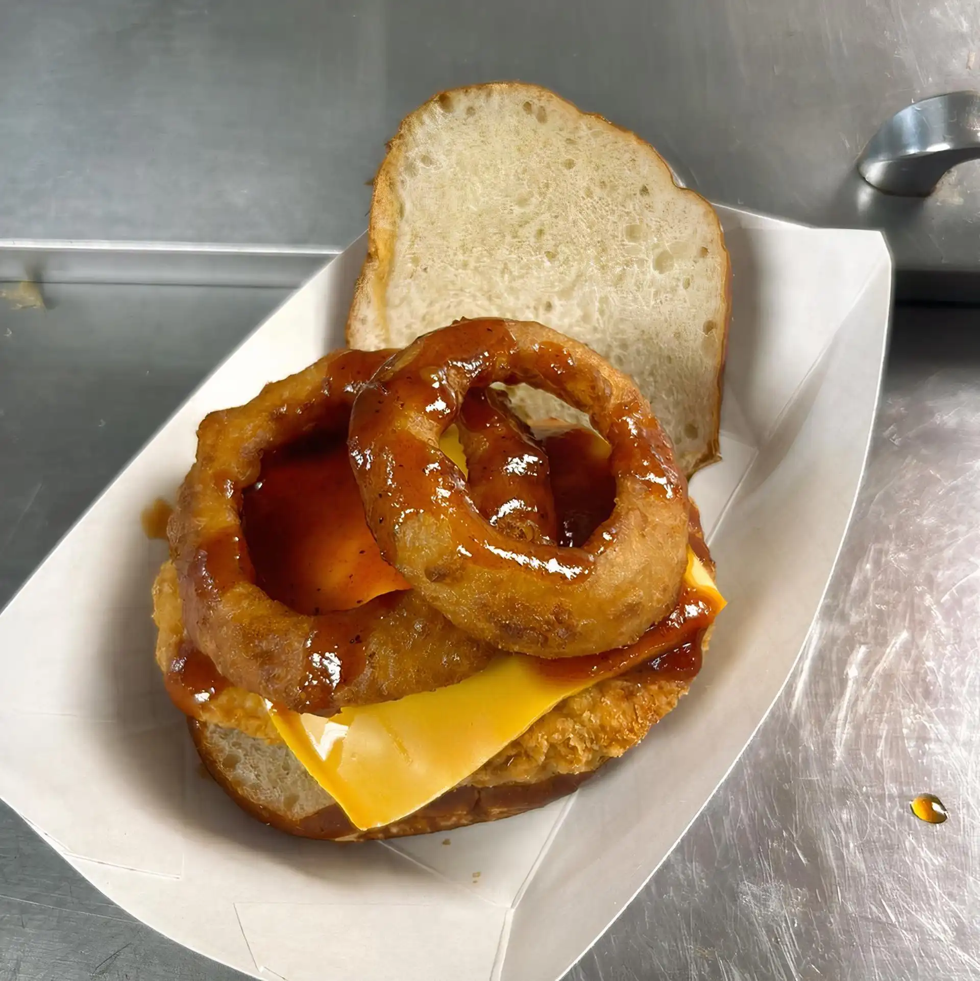 Fried 6 oz. Chicken Breast served on a Pretzel Bun with 2 Onion Rings, Cheddar, and House Made BBQ Sauce