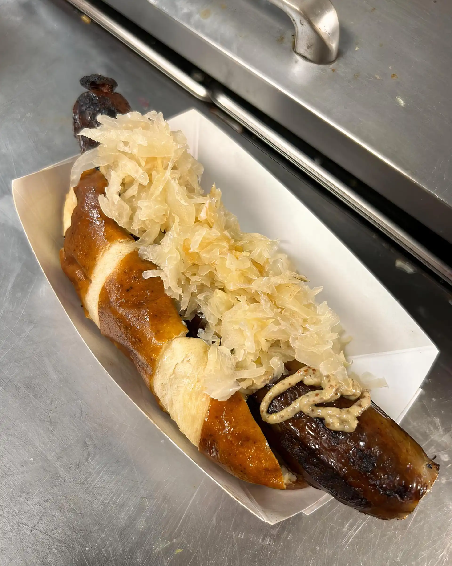 Founders Brewery beer bratwurst on a pretzel bun with sauerkraut and IPA beer mustard