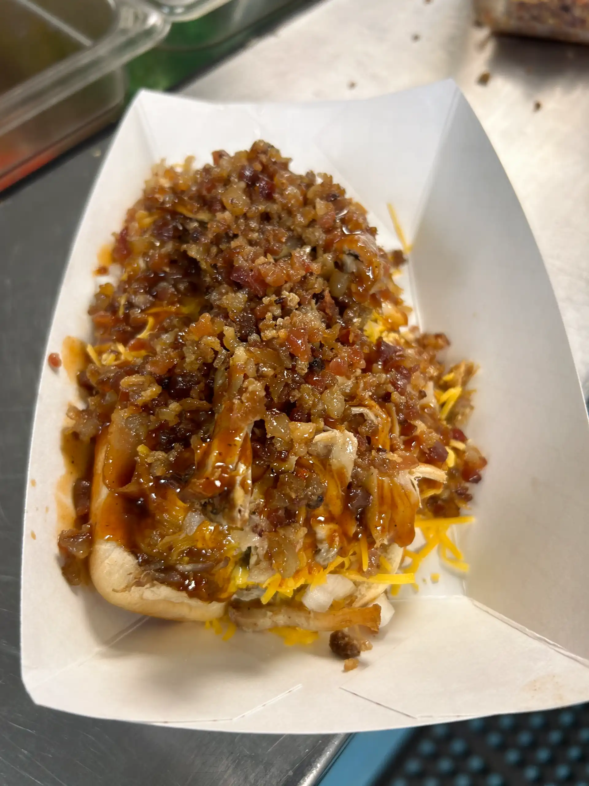 Smoked all beef 1/4 lb. wien with it all! Nacho cheese, chili, pulled pork, bacon bits, onion, and jalapeño's