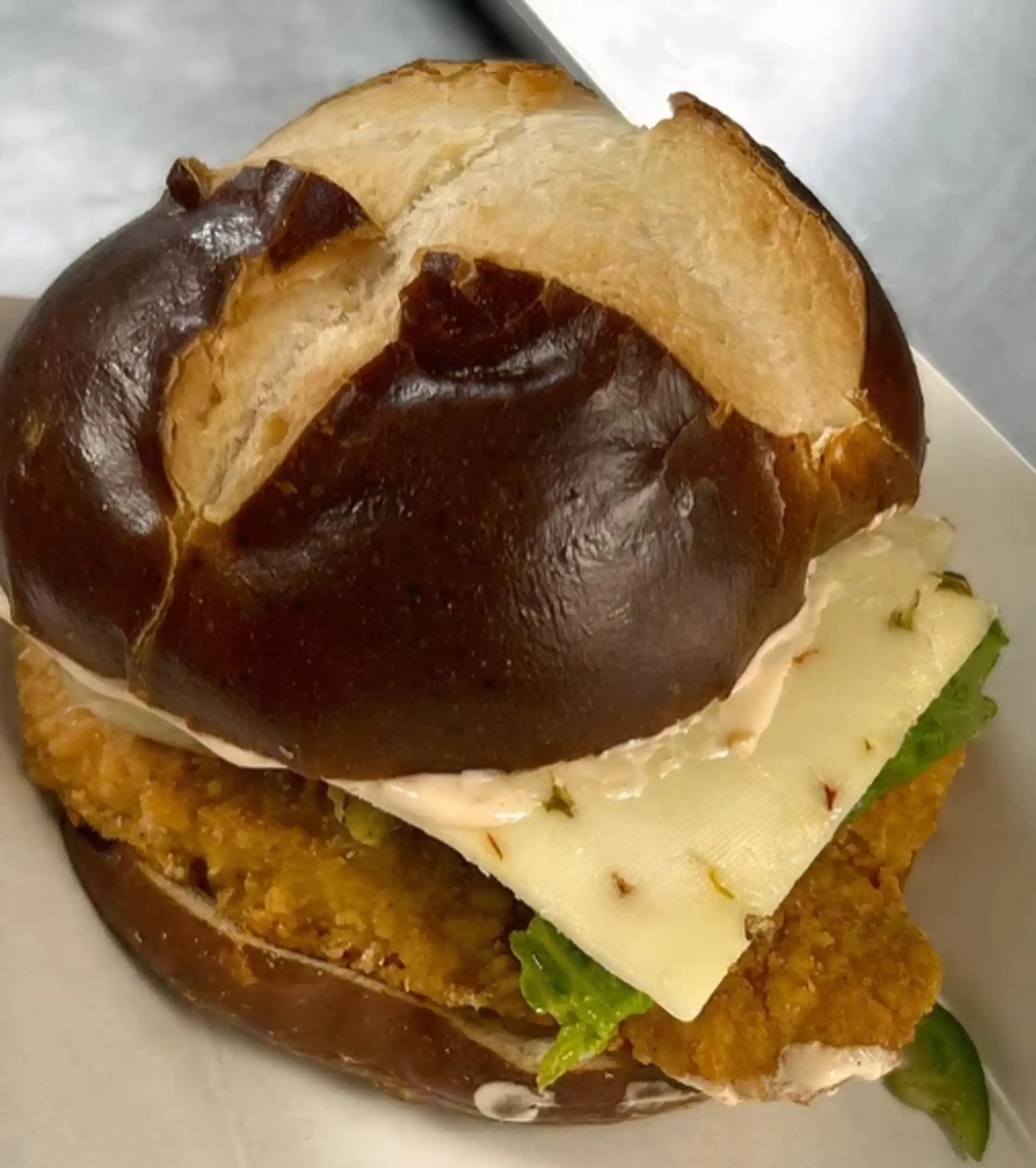 Fried 6 oz. Chicken Breast served on a Pretzel Bun with Bacon, Lettuce, Tomato, Cheddar, Fresh Jalapeños, and House Made Scorpion aioli