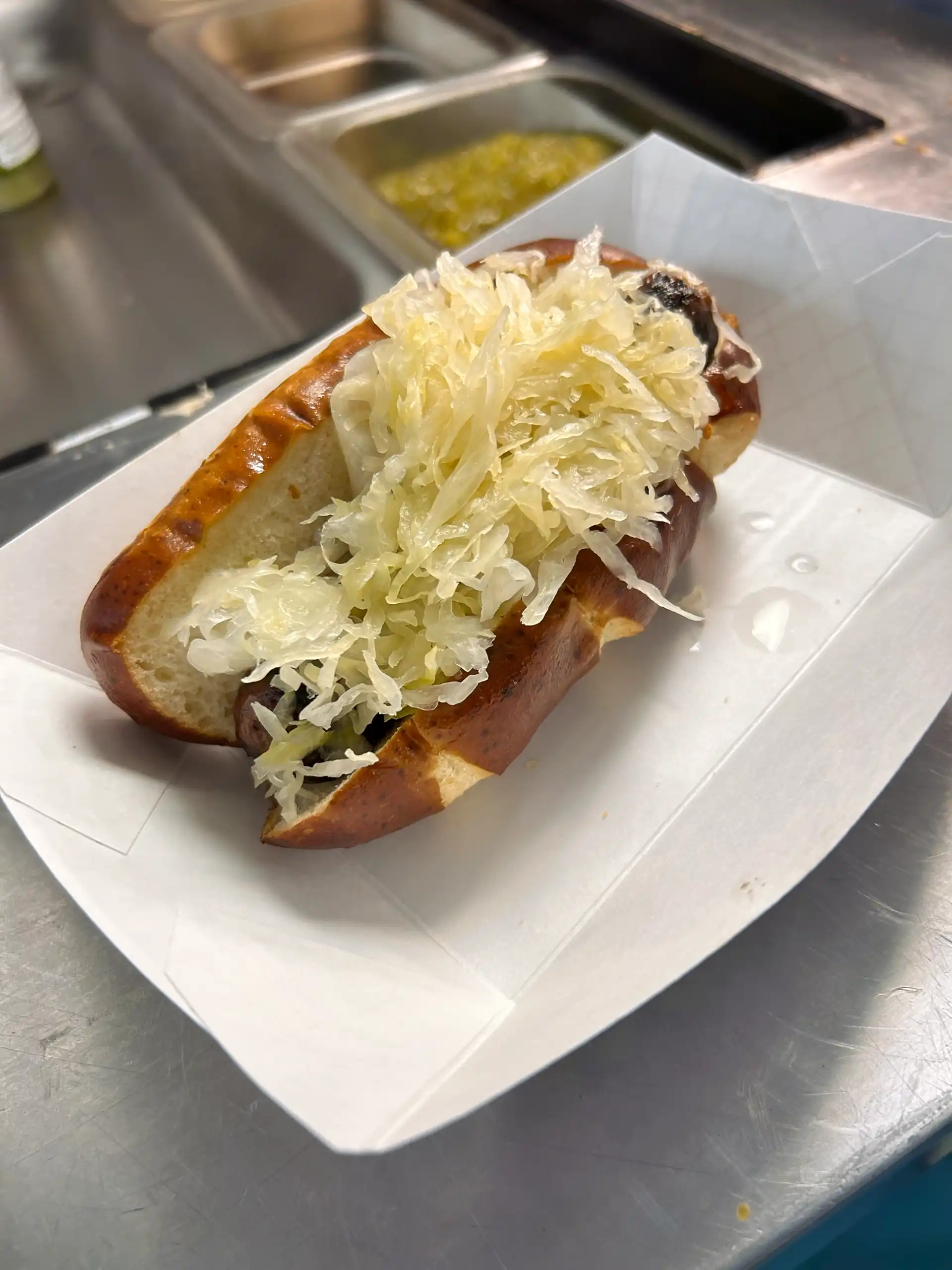 Bratwurst on a pretzel bun with sauerkraut and mustard