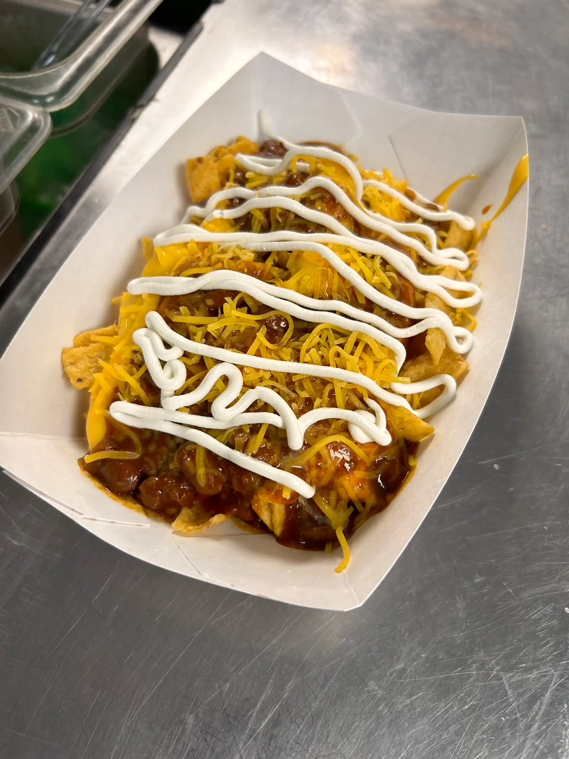 Fritos with chili, nacho cheese, shredded cheese, onion, jalapeño's, and sour cream