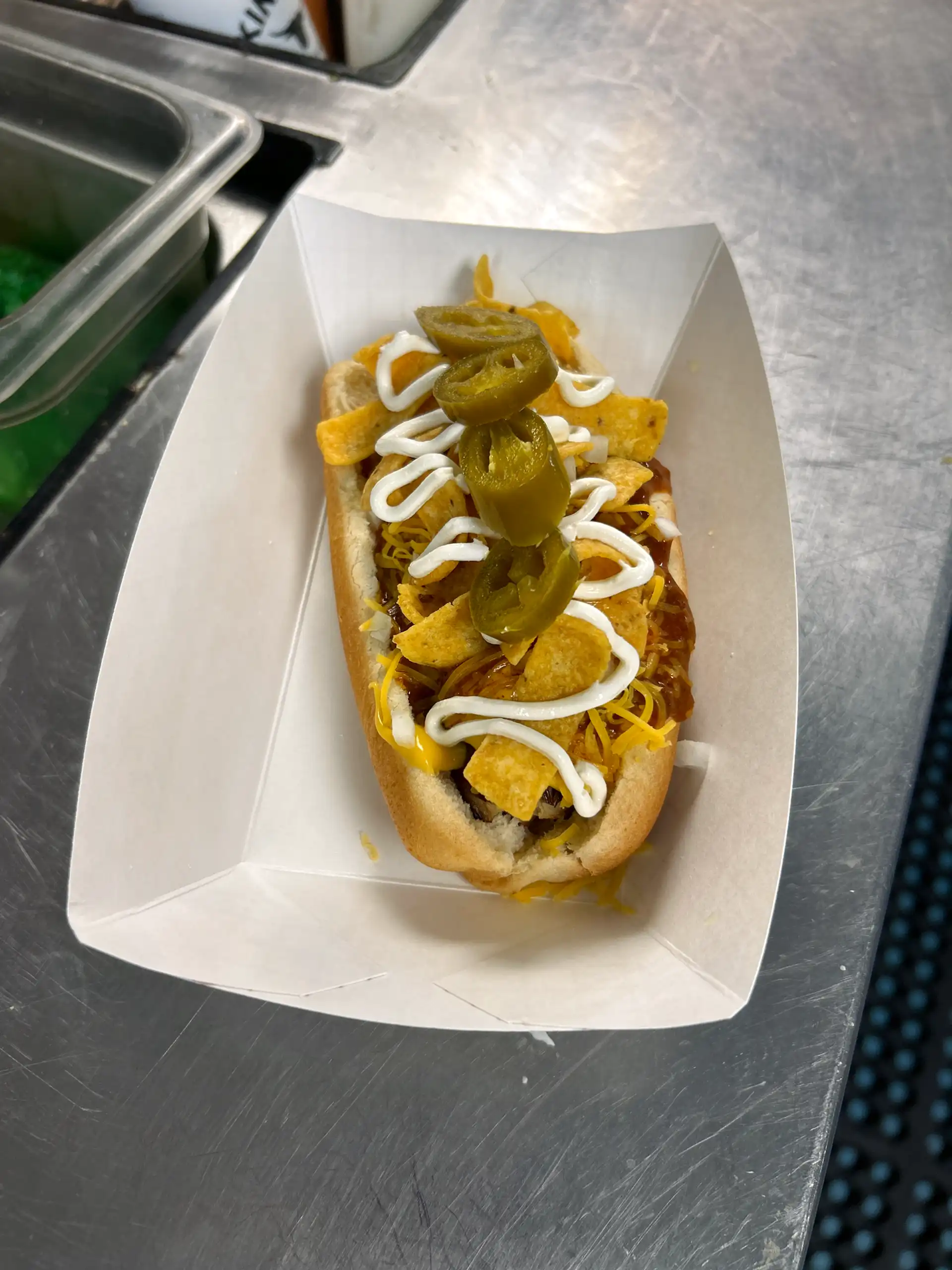 Smoked all beef 1/4 lb. wien with chili, nacho cheese, shredded cheese, onion, jalapeño's, and sour cream